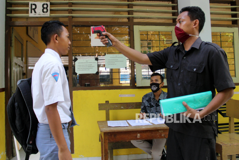 Tenaga pengajar melakukan pengecekan suhu tubuh siswa (ilustrasi). Tahun ajaran baru sekaligus kegiatan belajar mengajar di Jawa Timur akan dimulai pada 13 Juli 2020 dan berlangsung secara daring.