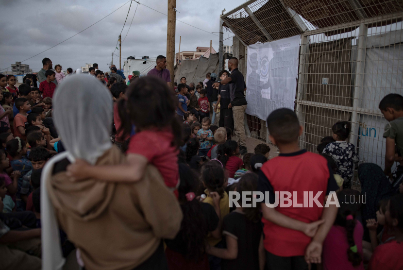 Anak-anak berkumpul di bioskop darurat yang didirikan di antara tenda-tenda kamp pengungsi Rafah, Jalur Gaza bagian selatan, 28 April 2024. 