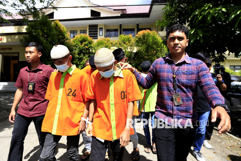 Polisi menggiring tersangka kasus rudapaksa anak di bawah umur, di Polda Gorontalo, Kabupaten Gorontalo, Gorontalo, Kamis (30/1/2025). Polda Gorontalo menetapkan 19 orang sebagai tersangka kasus rudapaksa seorang anak berusia 14 tahun yang terjadi di tiga tempat kejadian perkara di Kota dan Kabupaten Gorontalo, enam tersangka ditahan sedangkan tersangka lainnya dikenakan wajib lapor dan menunggu pendampingan karena masih di bawah umur.  