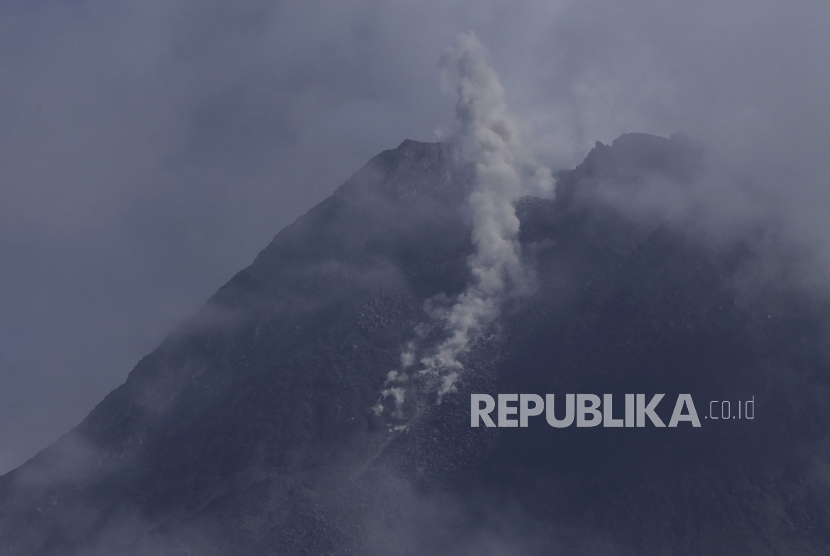 Gunung Merapi memuntahkan uap vulkanik dari kawahnya dilihat dari Sleman, Yogyakarta, Indonesia, Kamis 7 Januari 2021. Gunung setinggi 2.968 meter (9.737 kaki) itu memuntahkan longsoran awan panas pada Kamis pagi di tengah aktivitas vulkaniknya yang meningkat.