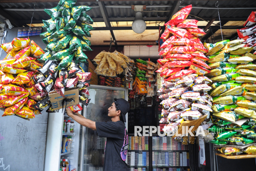 Penjaga menata minuman dingin di warung madura Anugerah di Jakarta, Jumat (10/1/2025). Warung Madura yang secara lokasi, harga, dan jam operasional (24 jam) lebih unggul dari toko modern tersebut menjadi pilihan berbelanja kebutuhan dasar warga seperti minuman botol, sembako, snack, dan produk mandi.