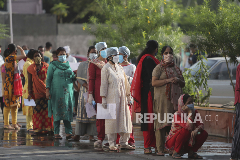  Orang-orang menunggu dalam antrian untuk mendaftarkan nama mereka agar sampel usap hidung mereka diambil untuk menguji COVID-19 di Jammu, India. Ilustrasi.