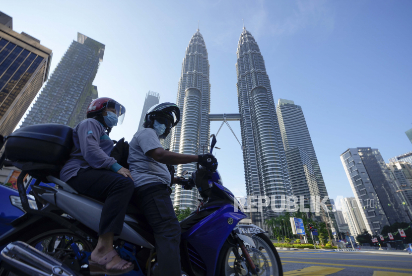 Gaji Menteri dan Wamen Malaysia Disumbangkan Tangani Covid-19. Pengendara yang mengenakan masker menunggu di depan Menara Kembar selama hari pertama Full Movement Control Order (MCO) di Kuala Lumpur, Malaysia, Selasa, 1 Juni 2021.