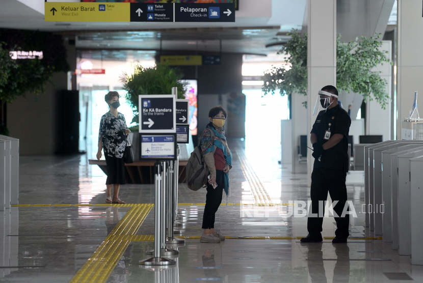 Petugas membantu penumpang untuk memasuki gerbong kereta bandara di Stasiun BNI City, Jakarta, Rabu (1/7). Kereta api bandara  Soekarno-Hatta kembali melayani penumpang mulai hari ini Rabu (1/7) dengan menerapkan protokol kesehatan pencegahan Covid-19 yang harus dipatuhi bagi para calon penumpang dan petugas.Prayogi/Republika.