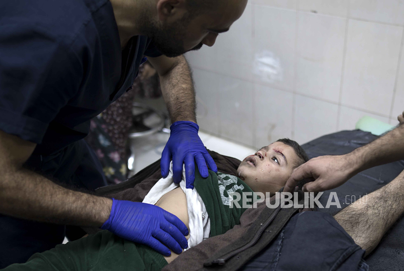  A Palestinian doctor checks a child injured following Israeli airstrikes in southern Gaza at the Nasser Hospital in Khan Yunis, southern Gaza Strip, 14 December  2023. Israeli forces resumed military strikes on Gaza after the week-long truce ended on December 1. At least 18,000 Palestinians and at least 1,200 Israelis have been killed, according to the Palestinian Health Ministry and the Israel Defense Forces (IDF), since Hamas militants launched an attack against Israel from the Gaza Strip on 07 October, and the Israeli operations in Gaza and the West Bank which followed it.  