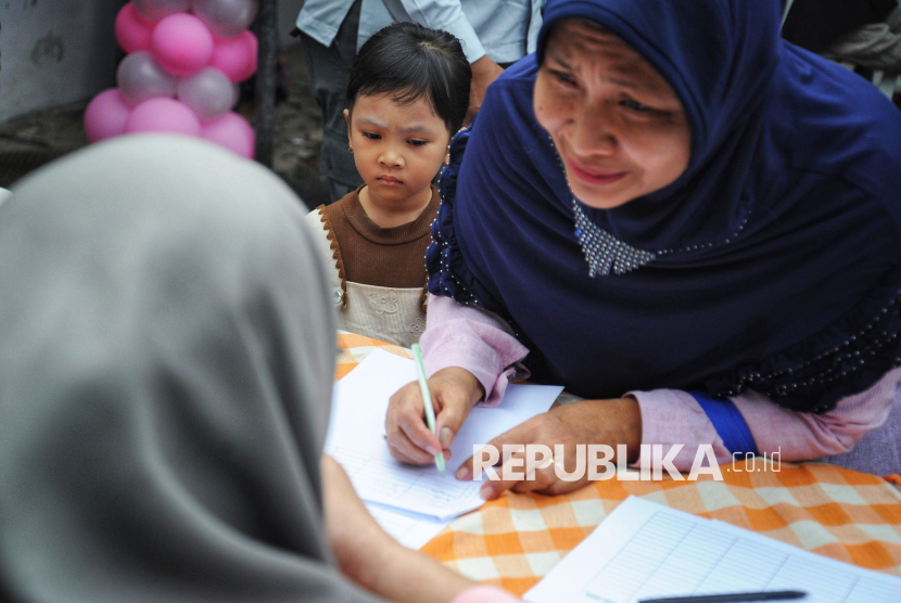 Orangtua bersama anak balitanya mengisi daftar hadir saat pembagian makan bergizi gratis (MBG) untuk balita, ibu hamil, dan ibu menyusui di Posyandu Dahlia, Ciracas, Jakarta, Jumat (10/1/2025). Pemerintah memulai program makan bergizi gratis untuk ibu hamil, ibu menyusui, hingga anak balita.  Progam MBG untuk balita, ibu hamil, dan ibu menyusui tersebut merupakan kelanjutan dari program MBG untuk pelajar yang telah dilaksanakan sejak Senin (6/1/2025) lalu. Adapun menu makanan untuk balita di lokasi tersebut hari ini yaitu nasi putih, telur, sayur labu, buah jeruk, dan susu. Program pemberian makan bergizi gratis ini diberikan untuk pemenuhan gizi ibu hamil, balita dan ibu menyusui terjaga. Selain itu juga mencegah stunting.