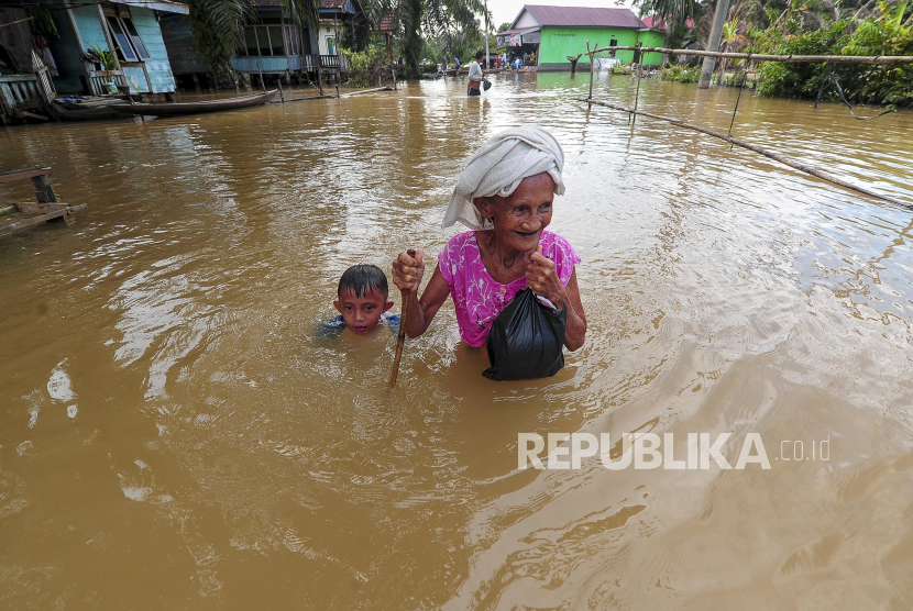 Warga menerobos jalan yang tergenang banjir. Hujan seharian buat banjir terjadi di Jakarta paling tinggi 1,2 meter di Jaktim.
