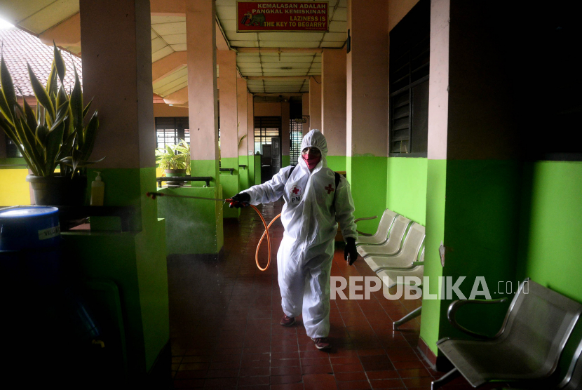 Petugas Palang Merah Indonesia (PMI) melakukan penyemprotan disinfektan di lingkungan SMP Negeri 43 Jakarta, Kamis (20/10/2022). Epidemolog menyarankan PTM 100 persen dihentikan untuk sementara di tengah meningkatnya penularan varian Omicron.