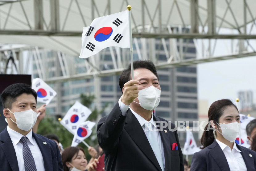 Presiden Korea Selatan Yoon Suk Yeol mengibarkan bendera nasional selama upacara untuk merayakan Hari Pembebasan Korea dari pemerintahan kolonial Jepang pada tahun 1945, di alun-alun kantor kepresidenan di Seoul, Korea Selatan, Senin, 15 Agustus 2022. Yoon akan menghadiri pemakaman Ratu Elizabeth dan Sidang Majelis Umum ke-77 PBB pada September.
