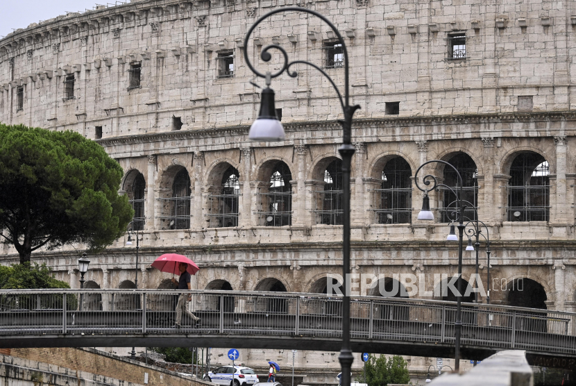 Orang-orang melewati Colosseum pada hari hujan di Roma, Italia, 31 Agustus 2020. Italia merupakan negara Eropa pertama yang dilanda wabah Covid-19.