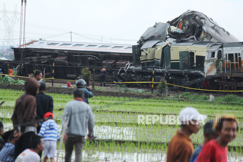 Warga melihat peristiwa tabrakan kereta api KA Turangga jurusan Surabaya-Bandung dengan KA commuter line jurusan Padalarang-Cicalengka, yang berlokasi tidak jauh dari Stasiun Cicalengka, Kabupaten Bandung, Jawa Barat, Jumat (5/1/2023). Belum diketahui penyebab tabrakan dua kereta ini. Pihak PT KAI menyatakan penyebab kecelakaan baru bisa diketahui setelah ada investigasi. Pada peristiwa tersebut 4 orang tewas, dan 37 luka-luka.
