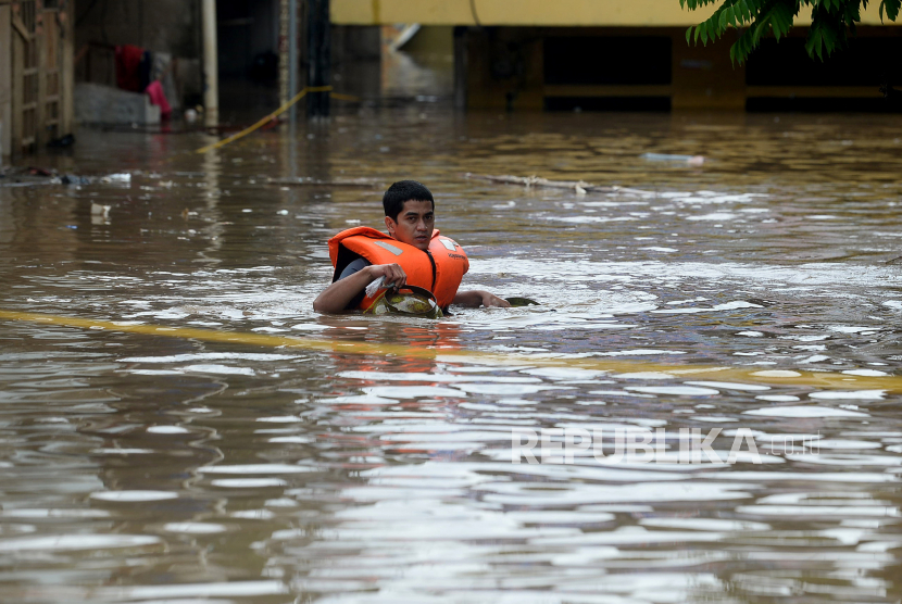 Warga melewati banjir yang merendam di kawasan Rawajati Kalibata, Jakarta, Senin (8/2). Ratusan rumah warga di Rawajati terendam banjir luapan Kali Ciliwung dengan ketinggian air mencapai 1 meter hingga 2 meter. Prayogi/Republika 
