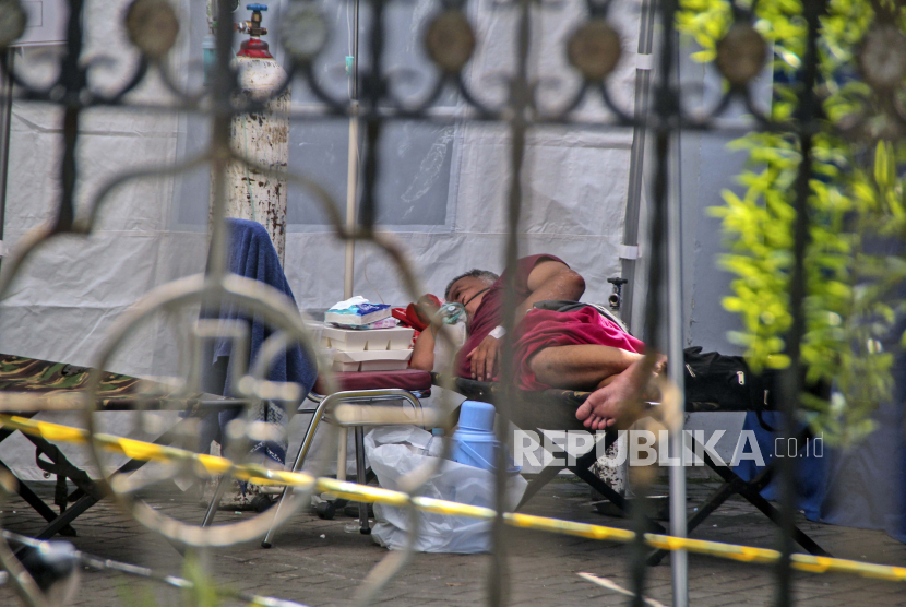Seorang pasien berbaring di ranjang bayi di dalam tenda darurat yang didirikan untuk menampung lonjakan kasus infeksi COVID-19, di Rumah Sakit Umum Dr. Sardjito di Yogyakarta, Indonesia, Rabu, 7 Juli 2021.