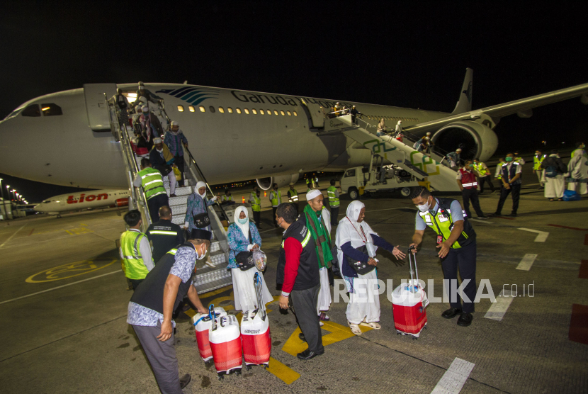 Petugas membantu jamaah haji kloter pertama embarkasi Banjarmasin saat tiba di Bandara Internasional Syamsudin Noor, Banjarbaru, Kalimantan Selatan, Senin (10/7/2023). 
