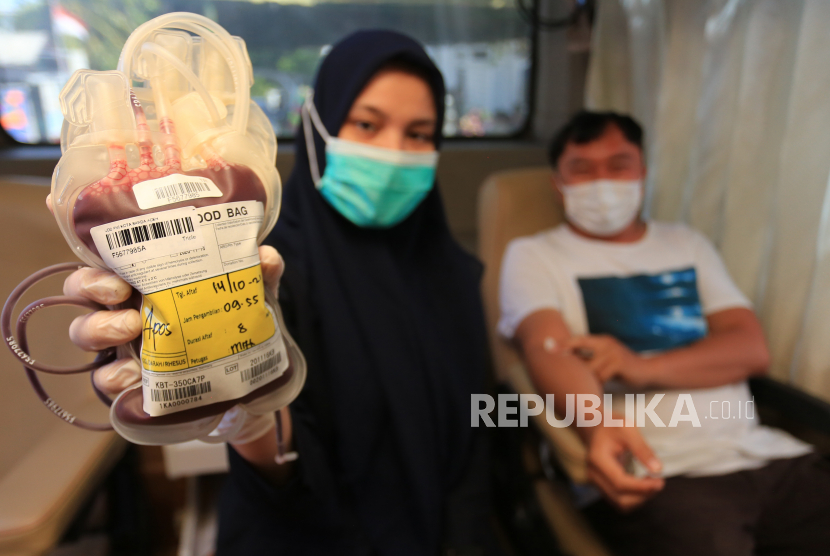 Petugas Unit Transfusi Darah Palang Merah Indonesia (PMI) menunjukkan kantong darah saat aksi jemput bola donor darah.