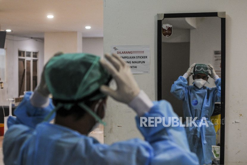 Tenaga kesehatan memakai alat pelindung diri di RSDC Wisma Atlet, Kemayoran, Jakarta.