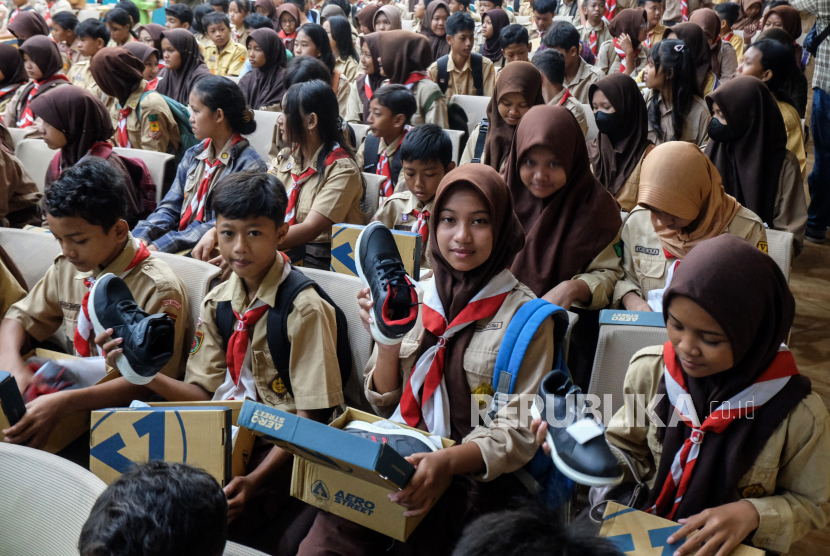 Sejumlah siswa menunjukkan sepatu yang dibagikan secara gratis di aula SMK N 8 Solo, Jawa Tengah, Jumat (26/4/2024). Sebanyak 1.100 sepatu dibagikan pada kesempatan tersebut melalui program tanggung jawab sosial perusahaan (CSR) sepatu lokal untuk membantu siswa kurang mampu dengan memberikan alas kaki yang lebih layak guna menunjang kegiatan belajar mereka di sekolah. 