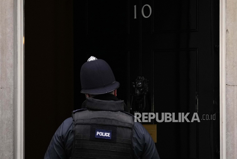 Seorang petugas polisi berdiri di depan 10 Downing Street di London, Rabu, 26 Januari 2022.