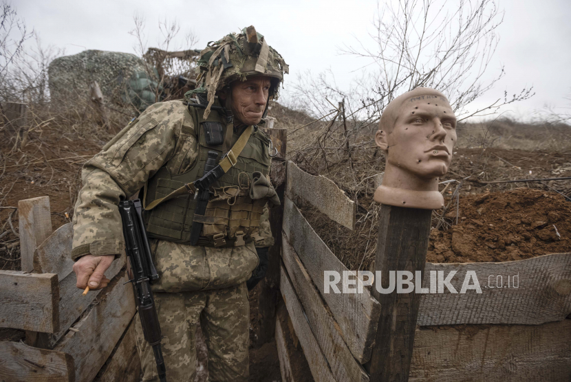 Seorang tentara Ukraina berjalan di parit di garis pemisah dari pemberontak pro-Rusia, wilayah Donetsk, Ukraina, Ahad 9 Januari 2022. 
