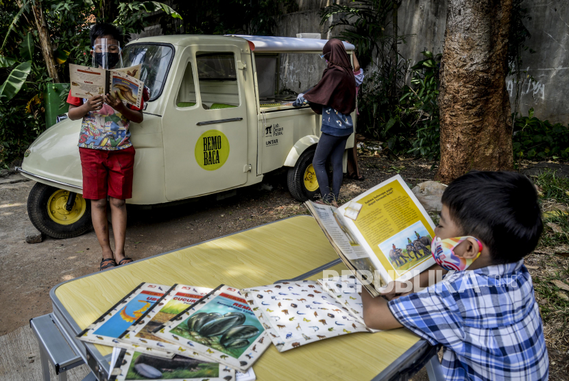 Anak-anak membaca buku yang disediakan oleh Bemo Baca milik Sutino (60) saat peringatan Hari Aksara Internasional (ilustrasi).