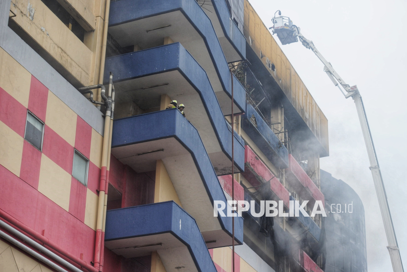 Petugas pemadam kebakaran melakukan proses pendinginan setelah terjadi kebakaran di Glodok Plaza, Jakarta, Kamis (16/1/2025).  Sebanyak 45 unit mobil dan 230 personil pemadam kebakaran dikerahkan ke lokasi kebakaran Glodok Plaza yang terjadi pada Rabu (15/1/2025) malam. Menurut data sementara hingga pukul 13.23 WIB hari ini, Tim gabungan berhasil mengevakuasi 9 orang korban selamat dan 7 orang masih dalam pencarian.