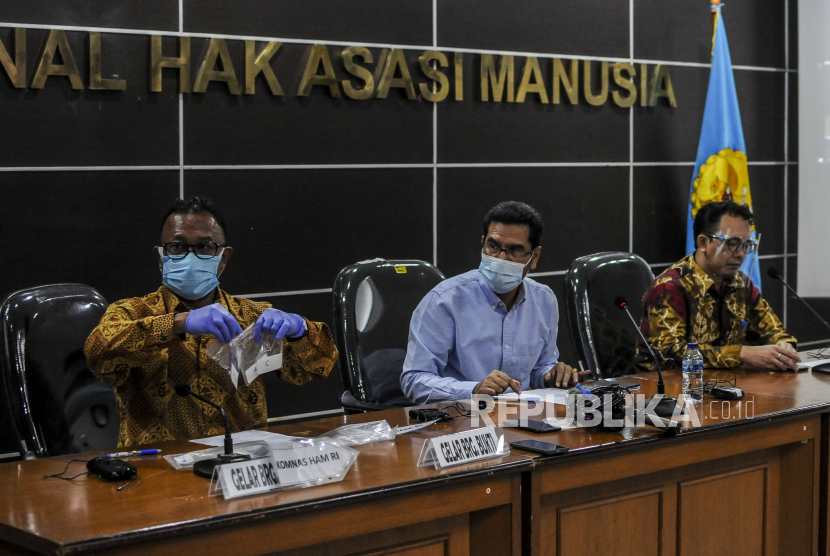 Komisioner Komnas HAM Amiruddin (tengah) bersama Choirul Anam (kiri) dan Beka Ulung Hapsara menunjukkan barang bukti hasil penyelidikan saat konferensi pers di Jakarta.