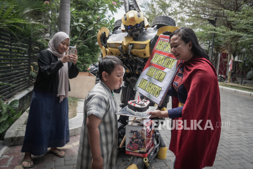 Relawan memakai kostum superhero Transformers memberikan kejutan ulang tahun kepada anak yatim piatu di Desa Gentan, Sukoharjo, Jawa Tengah, Ahad (6/8/2023). Kegiatan dalam rangka menyambut kemerdekaan Republik Indonesia tersebut untuk berbagi kebahagian kepada anak yatim piatu yang lahir di bulan Agustus. 