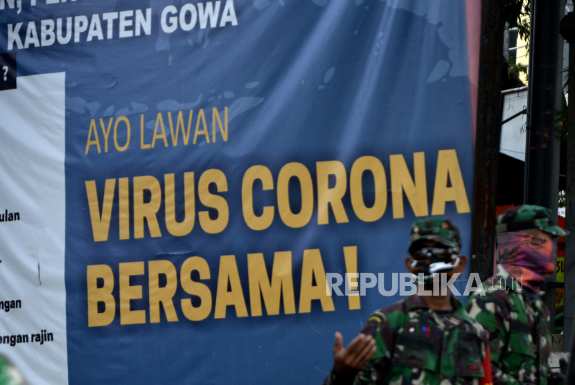 Anggota TNI melakukan penjagaan di dekat spanduk bertuliskan Ayo Lawan Virus Corona Bersama di Kabupaten Gowa, Sulawesi Selatan, Sabtu (16/5). (ilustrasi)