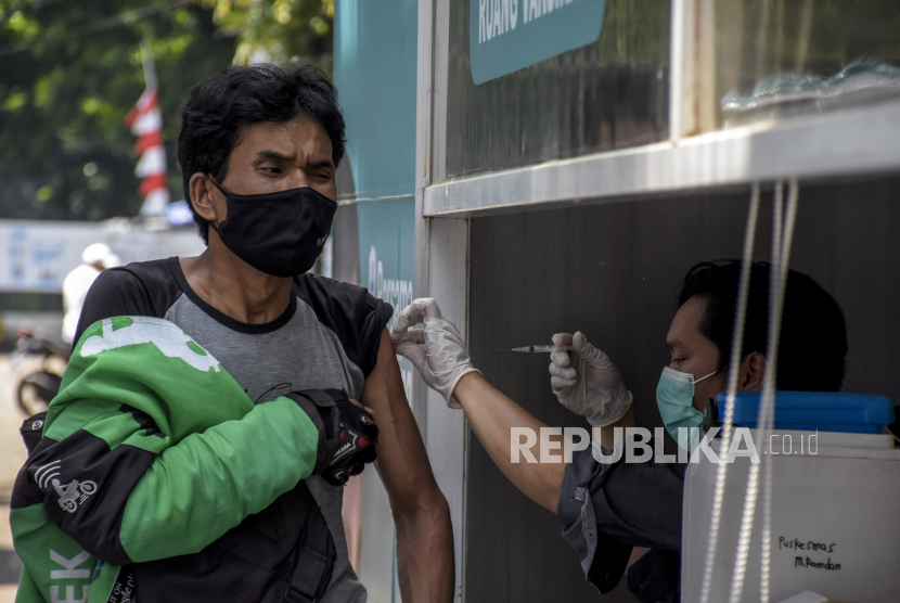 Vaksinator menyuntikkan vaksin Covid-19 ke warga saat pelaksanaan vaksinasi menggunakan sistem layanan tanpa turun (lantatur) di Taman Tegallega, Kota Bandung, Selasa (9/11). Kementerian Kesehatan merilis, hingga hari ini (9/11) pukul 12.00 WIB jumlah penduduk yang telah divaksinasi Covid-19 dosis pertama mencapai 126.459.285 juta jiwa atau 60,72 persen dari 208.265.720 juta jiwa penduduk sasaran, sedangkan dosis kedua telah mencapai 80.070.525 juta jiwa atau 38,45 persen. Foto: Republika/Abdan Syakura