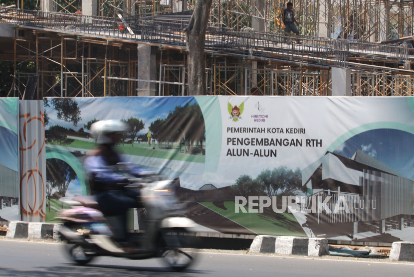 Pengendara motor melintas di sekitar proyek revitalisasi Alun-alun Kota Kediri, Jawa Timur, Senin (28/8/2023). Revitalisasi alun-alun dengan anggaran sebesar Rp23 miliar iitu bersumber dari Anggaran Pendapatan Belanja Daerah (APBD) Kota Kediri yang ditargetkan selesai pada akhir 2023. 