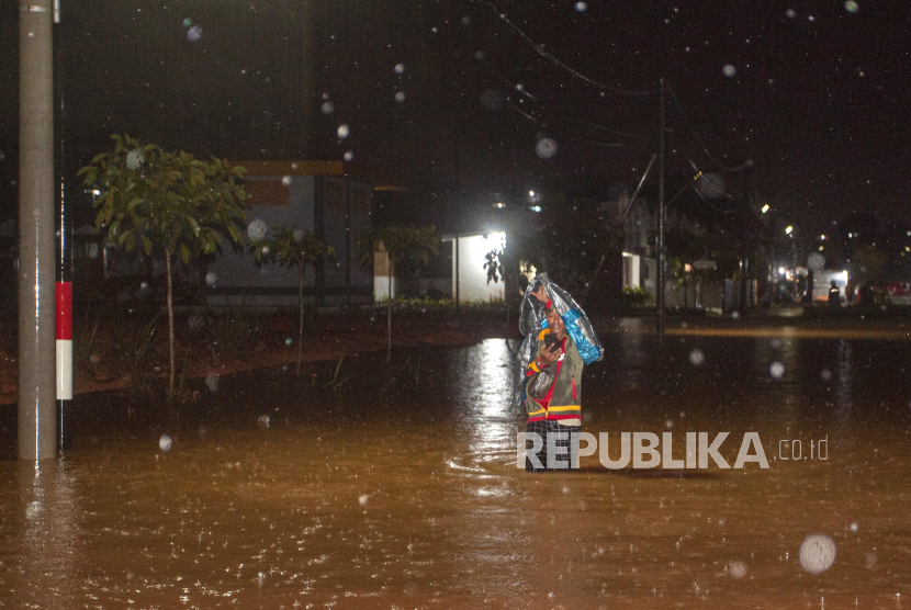 Warga melintasi banjir yang merendam salah satu kawasan permukiman di Batam, Kepulauan Riau. (ilustrasi). BPBD Riau menetapkan 9 daerah siaga banjir.