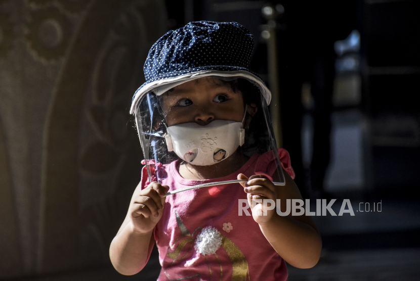 Seorang anak mengenakan masker dan pelindung wajah beraktivitas di area The Trans Luxury Hotel, Jalan Gatot Subroto, Kota Bandung, Kamis (11/6). Asupan nutrisi dan menjaga anak dengan menggunakan masker dan jaga jarak dengan orang lain dapat melindunginya dari risiko terkena Covid-19.