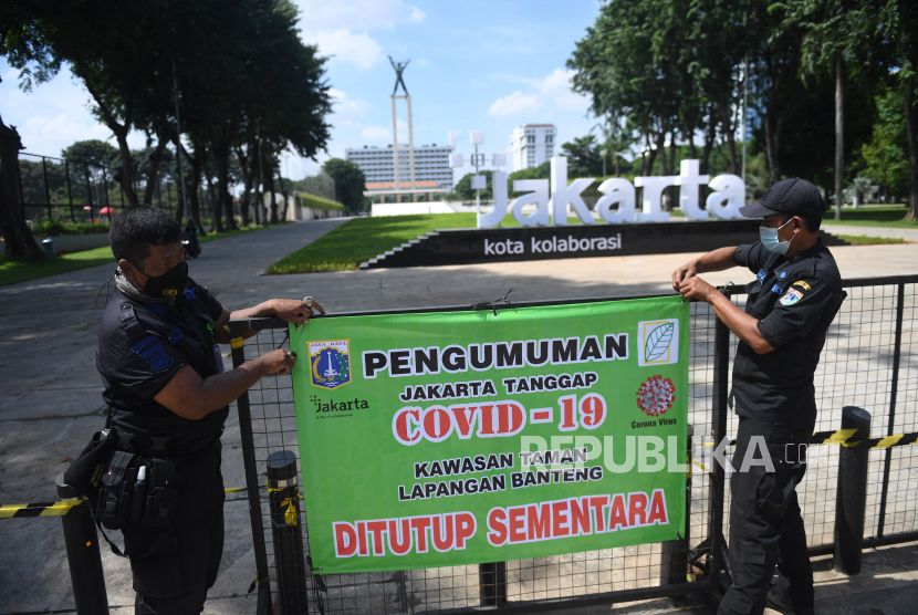 Petugas gabungan merapikan spanduk pengumuman ditutupnya Taman Lapangan Banteng di Jakarta, Jumat (25/6). Pemprov DKI Jakarta menutup kembali taman-taman kota di Jakarta selama masa Pemberlakukan Pembatasan Kegiatan Masyarakat (PPKM) Mikro untuk mencegah timbulnya kerumunan yang berpotensi menciptakan klaster baru Covid-19. 