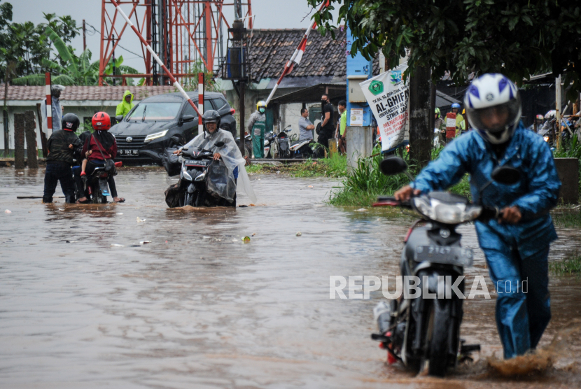 Warga mendorong motornya yang mogok akibat banjir di Jalan Cibiru Hilir, Kabupaten Bandung, Jawa Barat, Selasa (27/10/2020). Hujan yang mengguyur Bandung Raya sejak siang hingga sore hari membuat jalanan tersebut tergenang air setinggi 10 hingga 50 sentimeter akibat luapan sungai. 