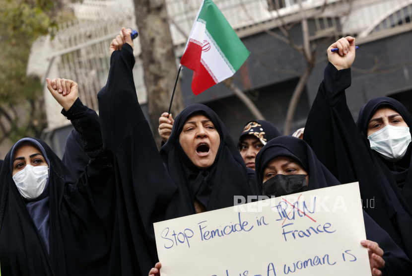 Pendukung pro-pemerintah, termasuk keluarga tentara Iran yang terbunuh, memprotes PBB dan negara-negara barat di depan kantor PBB di Teheran, Iran, 13 Desember 2022. Sekelompok orang Iran pro-pemerintah berkumpul di depan kantor PBB di Teheran mengutuk apa yang mereka gambarkan sebagai 