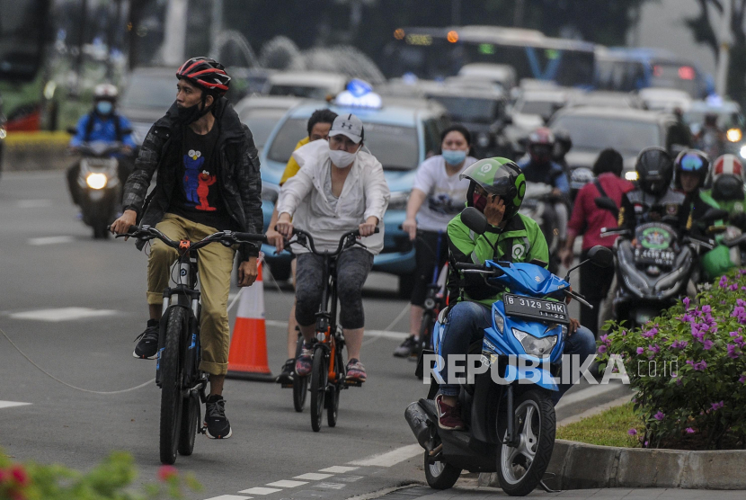 Sejumlah warga bersepeda di kawasan Sudirman, DKI Jakarta, Jumat (26/6). Jumlah kendaraan pribadi di Ibu Kota selama PSBB transisi hampir mendekati masa sebelum pandemi Covid-19.