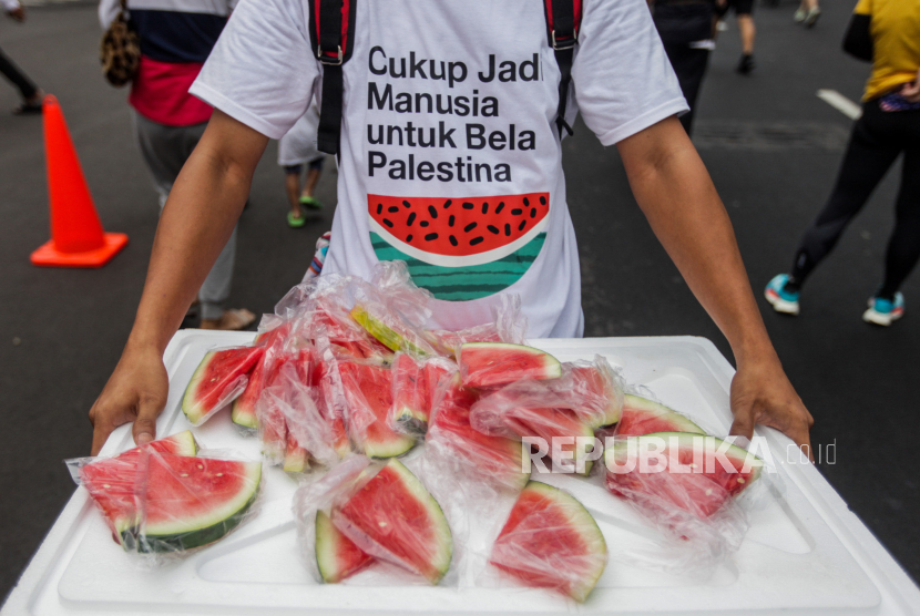 Volunteers distribute watermelons during pro-Palestinian march in the Sarinah area, Jakarta, Sunday (5/11/2023).