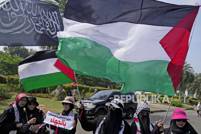 Para Muslimah Indonesia mengibarkan bendera Palestina saat unjuk rasa mendukung Palestina di Jakarta, Indonesia, Jumat, 13 Oktober 2023.