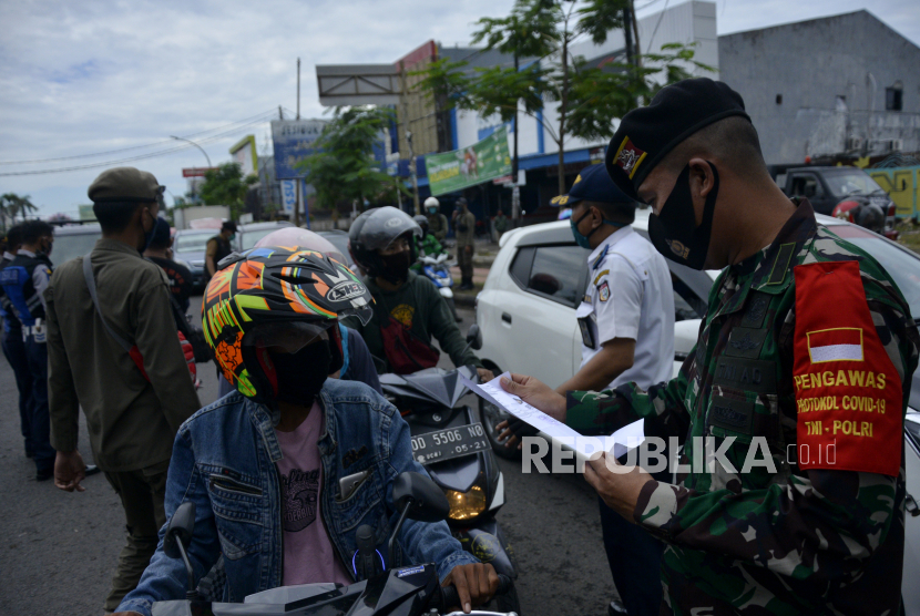 Petugas gabungan memeriksa surat keterangan bebas COVID-19 kepada sejumlah pengendara di perbatasan Makassar dan Kabupaten Gowa, Sulawesi Selatan. Ilustrasi