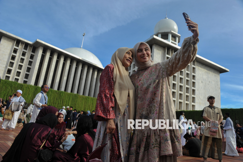 Jamaah berswafoto seusai melaksanakan Sholat Idul fitri di Masjid Istiqlal, Jakarta, Senin (31/3/2025). Faktor rajin beribadah disebut  berkorelasi dengan kebahagiaan.