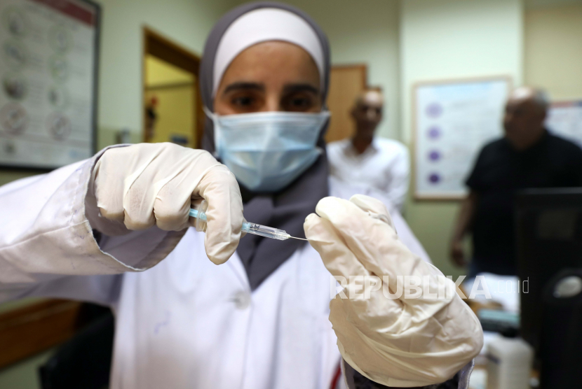 Pekerja medis Palestina menyiapkan dosis vaksin Pfizer-BioNTech melawan Covid-19 di Pusat Medis Palestina di kota Dura, Tepi Barat, 10 Juni 2021.
