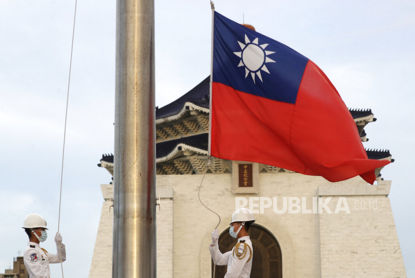  Dua tentara menurunkan bendera nasional Taiwan pada upacara bendera harian di Liberty Square of the Chiang Kai-shek Memorial Hall di Taipei, Taiwan, 30 Juli 2022.