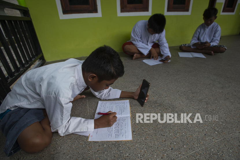 Tiga siswa menggunakan layanan panggilan video melalui telepon pintar dalam pembelajaran daring sekolah (ilustrasi)