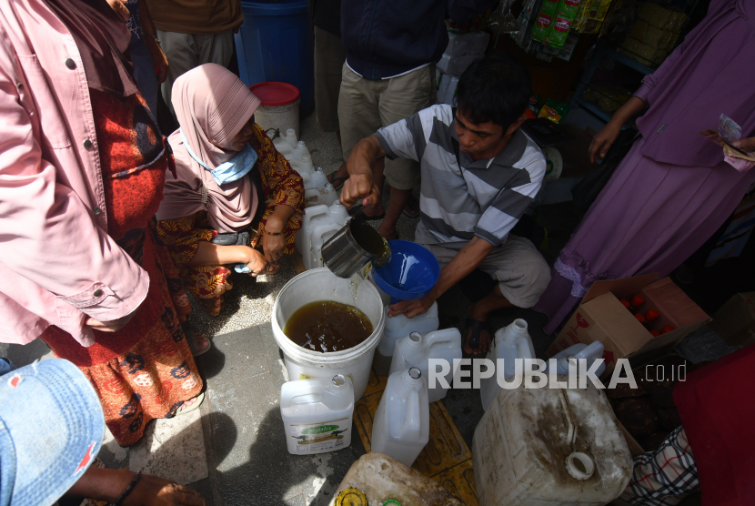 Pedagang pengecer melayani pembelian minyak goreng curah. Polres Banjar Polda Kalimantan Selatan menyiapkan minyak goreng bagi masyarakat penerima vaksin.