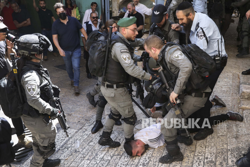 Petugas polisi Israel menahan seorang pemuda Palestina selama protes terhadap serangan udara Israel di Jalur Gaza dan konfrontasi kekerasan antara pasukan keamanan Israel dan Palestina, di Kota Tua Yerusalem, Selasa, 18 Mei 2021.
