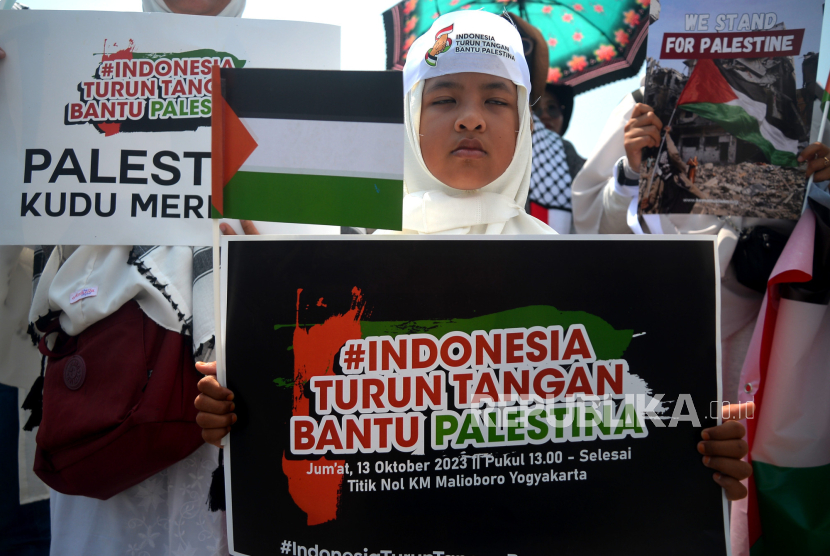 Peserta aksi dari Forum Umat Islam mengikuti Indonesia Turun Tangan Bantu Palestina di Titik Nol Yogyakarta, Jumat (13/10/2023). Pada aksi damai menyikapi pertempuran Israel-Palestina ini mereka menyerukan Pemerintah untuk ikut membantu Palestina dengan menggalang bantuan internasional. Selain itu, mereka juga melakukan penggalangan dana untuk membantu perjuangan rakyat Palestina. Pada akhir aksi peserta berdoa qunut nazilah bersamaan dengan Shalat Ashar berjamaah di lokasi aksi.