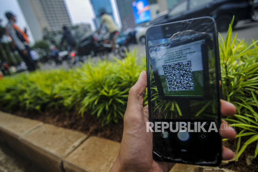 Warga memindai kode batang (QR code) tanaman yang terpasang di kawasan Bundaran HI, Jakarta, Jumat (25/1). Dinas Pertamanan dan Hutan Kota Provinsi DKI Jakarta memasang teknologi 