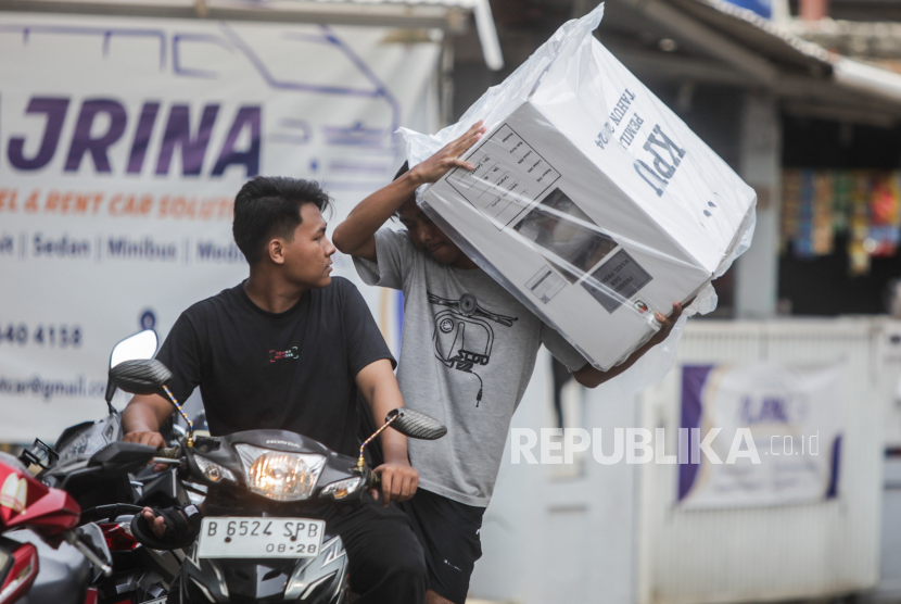 Warga membawa kotak suara untuk disimpan di salah satu TPS di kawasan Srengseng Sawah, Jakarta Selatan, Selasa (13/2/2024).