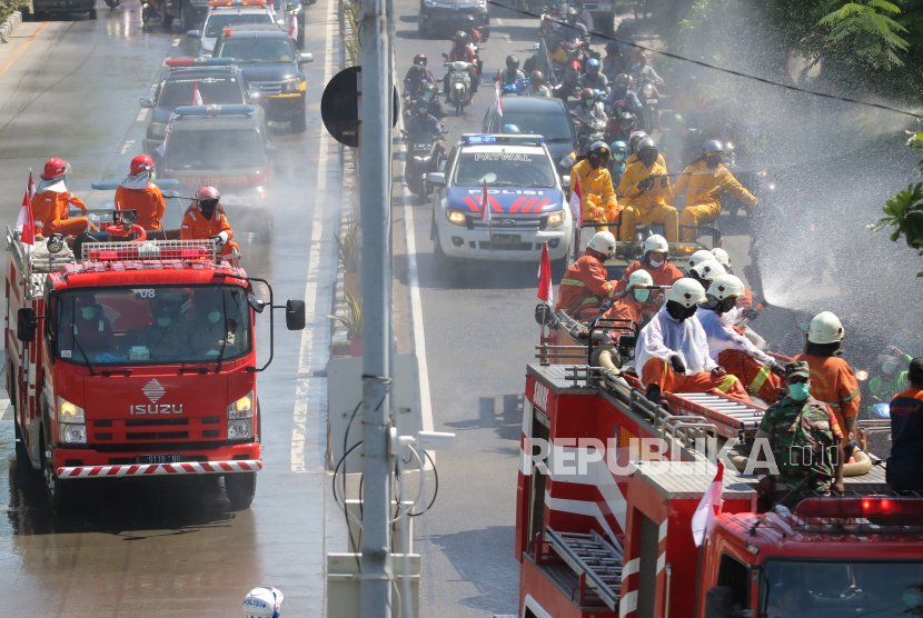 Petugas menyemprotkan cairan disinfektan di Jalan Kedung Cowek, Surabaya, Jawa Timur, Selasa (31/3/2020). Penyemprotan disinfektan di akses jalan menuju ke Jembatan Suramadu itu untuk mencegah penyebaran COVID-19