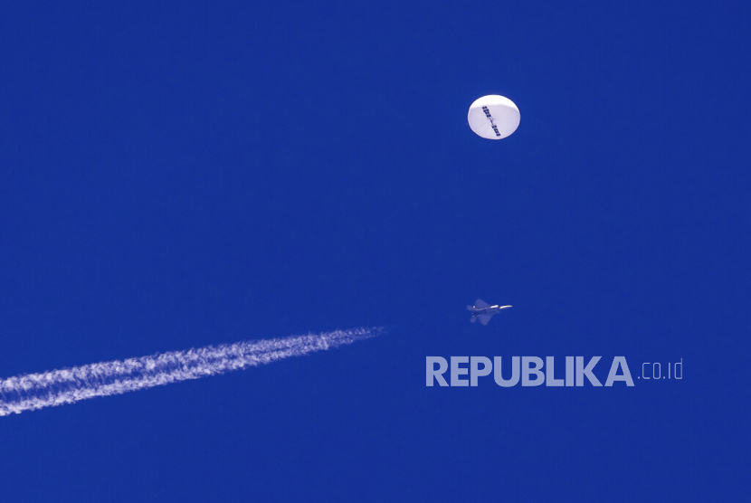 Sebuah balon besar mata-mata China melayang yang dicurigai dan jejak jet tempur terlihat di bawahnya di atas Samudra Atlantik, di lepas pantai Carolina Selatan,  4 Februari 2023.